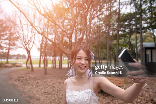 公共の公園で自分撮りの写真を撮る幸せな花嫁 - 記念撮影 ストックフォトと画像