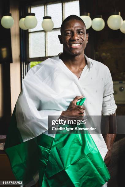 young man with the flag of the federal republic of nigeria - nigeria flag stock pictures, royalty-free photos & images