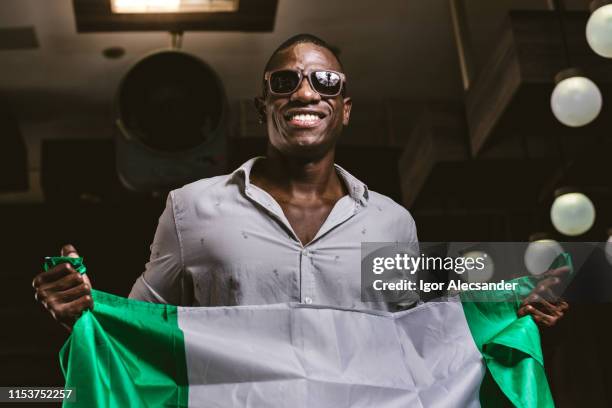 junger mann mit flagge der bundesrepublik nigeria - beauty fan event stock-fotos und bilder