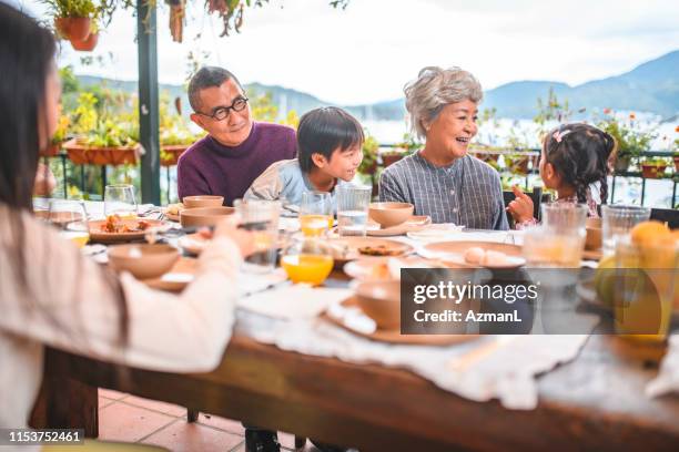 happy family sitting at dining table in back yard - chinese eating backyard stock pictures, royalty-free photos & images