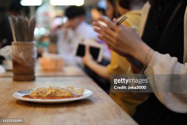 young woman enjoying foods at night market - taiwan night market stock pictures, royalty-free photos & images