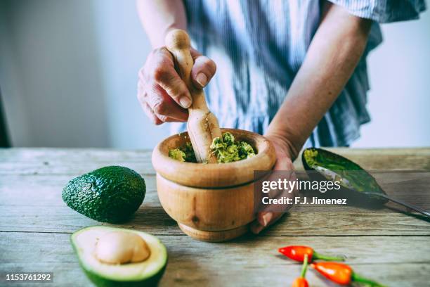 close-up of hands making homemade guacamole - mexican food catering stock pictures, royalty-free photos & images