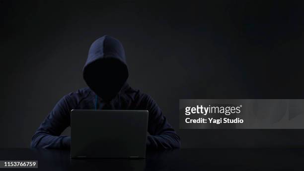 hacker in front of computer - anonimo imagens e fotografias de stock