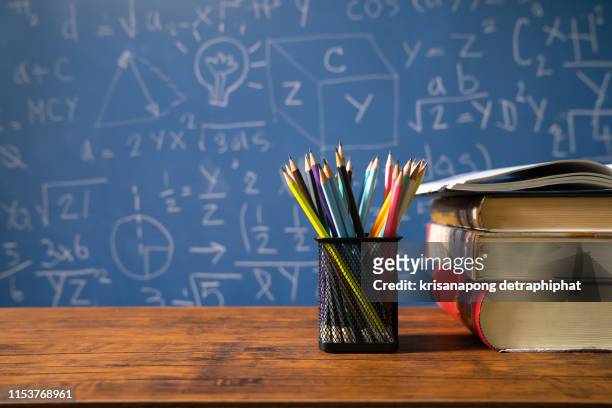 back to school supplies. books and blackboard on wooden background - workbook stock pictures, royalty-free photos & images