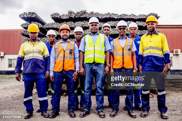 grupp porträtt av självsäker afrikansk stål fabrik worker team i afrika - fackförbund bildbanksfoton och bilder
