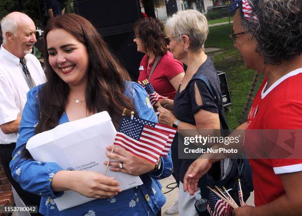 New U.S. Citizens receive congratulations and flags from members of the League of Women Voters following a special naturalization ceremony at the...