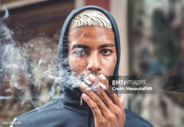 rebel boy smoking on the street - smoking issues stock pictures, royalty-free photos & images