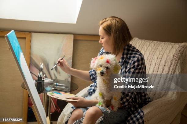 happy young woman paints on canvas - oil painting hands stock pictures, royalty-free photos & images