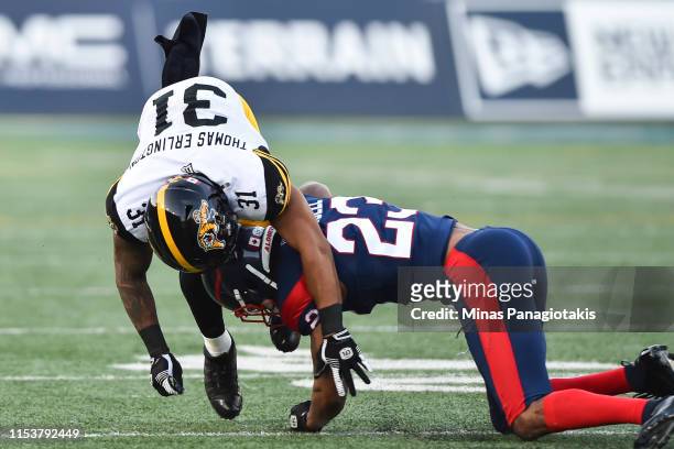 Tommie Campbell of the Montreal Alouettes tackles Sean Thomas-Erlington of the Hamilton Tiger-Cats during the CFL game at Percival Molson Stadium on...