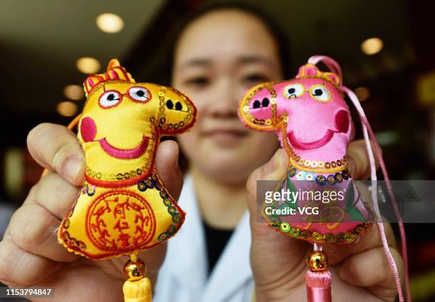 Staff member holds sachets featuring Peppa Pig characters at a store to welcome the upcoming Dragon Boat Festival, or Duanwu Festival, on June 3,...