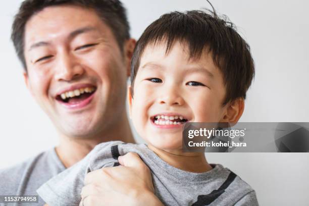 father and son relaxed at home - content japanese ethnicity stock pictures, royalty-free photos & images