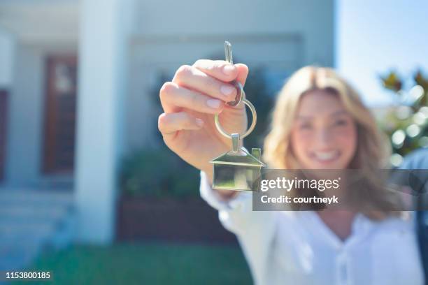 jovencita sosteniendo la llave de su nueva casa. - llavero fotografías e imágenes de stock