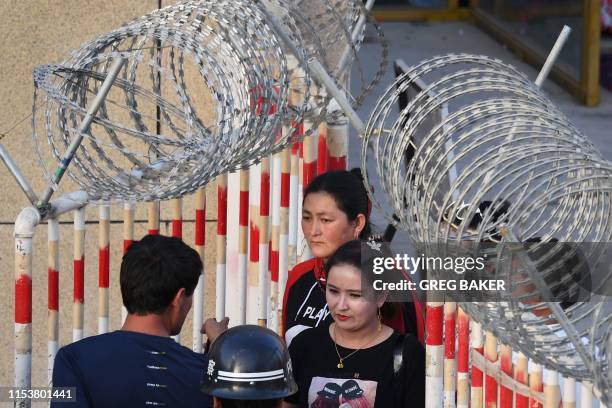 This photo taken on May 31, 2019 shows a Uighur woman going through an entrance to a bazaar in Hotan, in China's northwest Xinjiang region. - A...