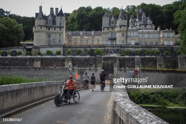 Cyclists stop on the road named "Loire a Velo", in front of the Chateau d'Usse, in Rigny-Usse, on July 2, 2019. "Loire a velo" is a 900-kilometres...