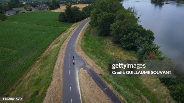 An aerial view taken on July 2, 2019 shows two cyclists on the road named "Loire a Velo" which is a 900-kilometres bicycle tour that links Cuffy near...