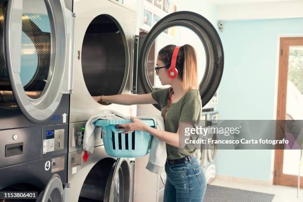 young woman in a launderette. - launderette stock-fotos und bilder