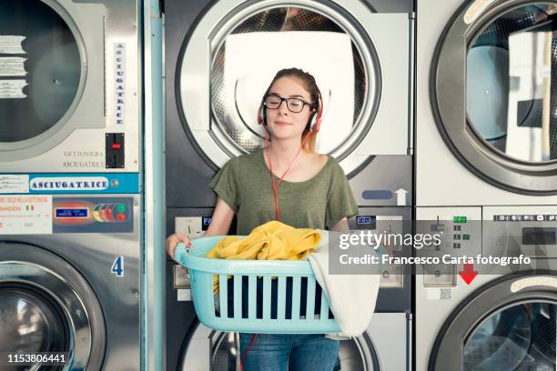 young woman in a launderette. - waschsalon stock-fotos und bilder