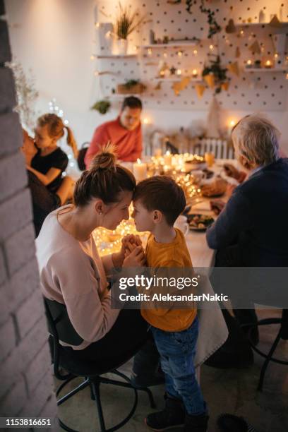 kinder beim weihnachtsessen mit der familie - familie essen weihnachten stock-fotos und bilder