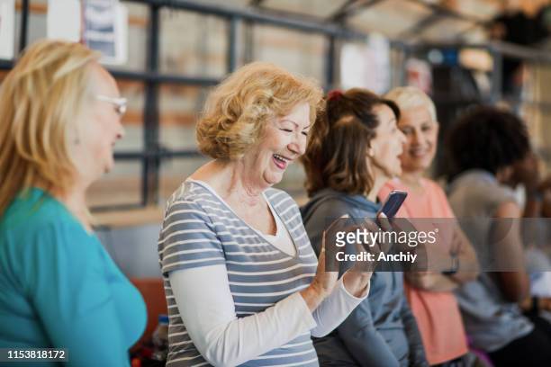 Senior woman using smartphone before dance class