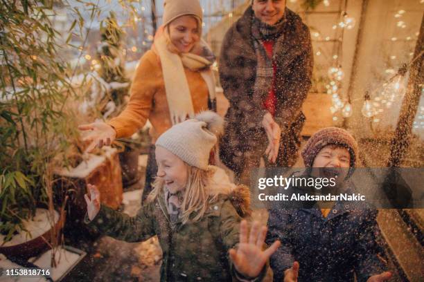 happy family enjoying winter day - father and mother with their daughter playing in the snow stock pictures, royalty-free photos & images