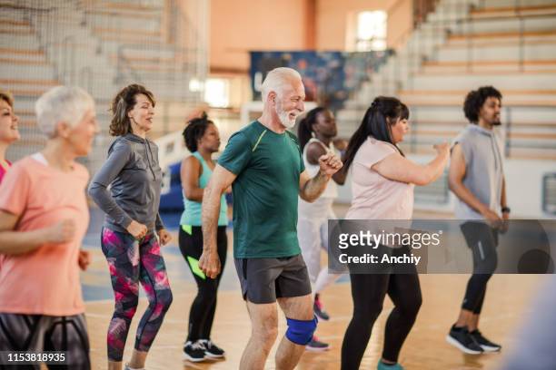 un gran grupo de personas bailando en la clase de zumba - exercise class fotografías e imágenes de stock