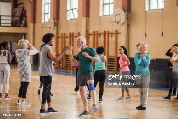 smiling, enthusiastic people cheering in dance class - kneepad stock pictures, royalty-free photos & images