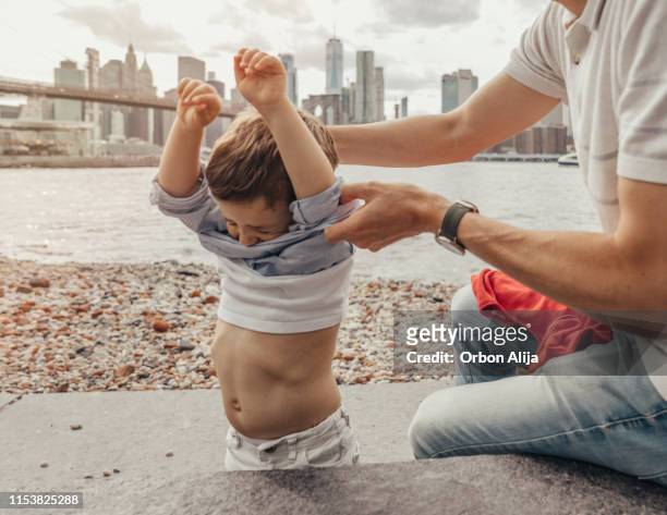 jongen die in het park van de brug van brooklyn, new york speelt - uitkleden stockfoto's en -beelden