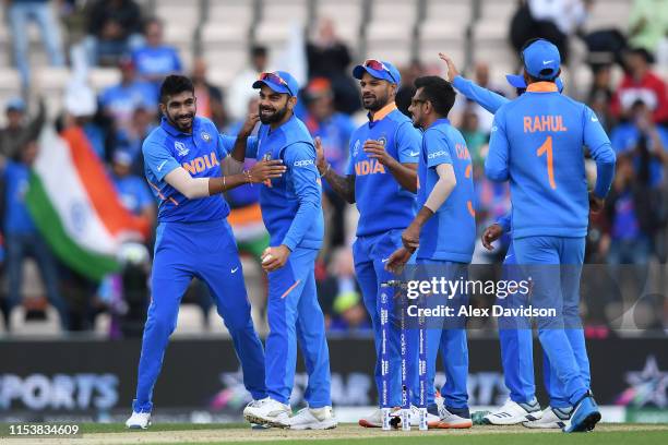 Jasprit Bumrah and Virat Kohli of India celebrate the wicket of Quinton De Kock of South Africa with their teammates during the Group Stage match of...