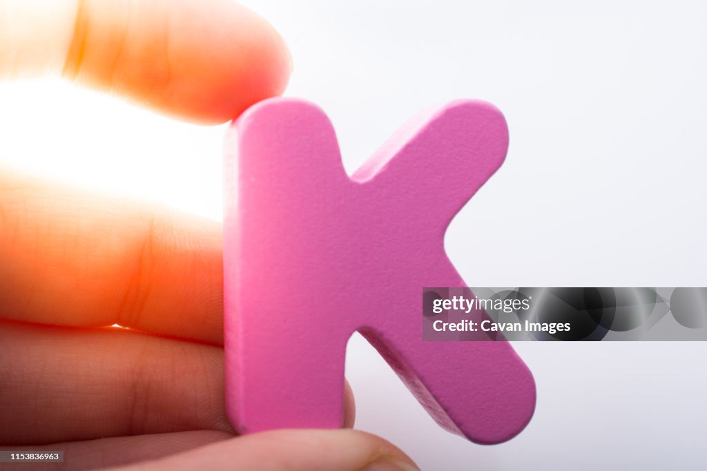 Hand holding Letter cube K of Alphabet