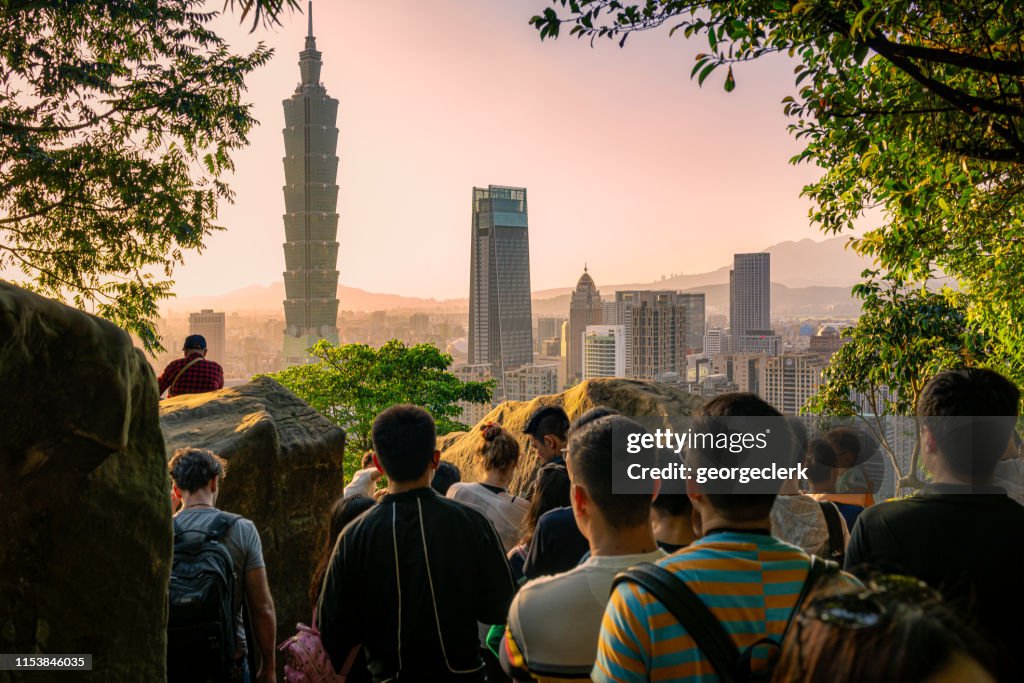 Multidões que recolhem para prestar atenção ao por do sol de Taipei