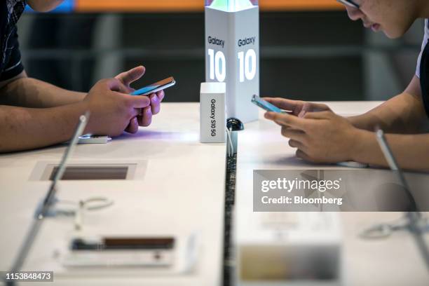 Customers look at Samsung Electronics Co. S10 5G smartphones at a store inside the company's headquarters in Seoul, South Korea, on Friday, July 5,...