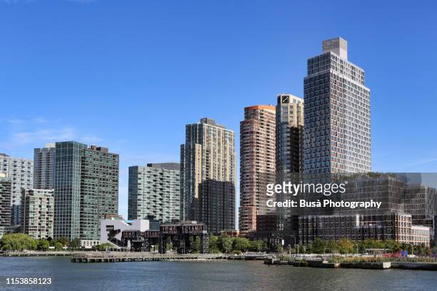 view of pier and highrise residential buildings at gantry plaza state park in long island city, queens, new york city - insel long island stock-fotos und bilder