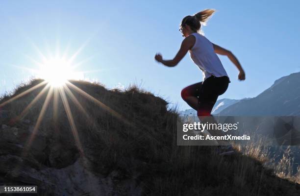 young woman runs to the top of a knoll at sunrise - personal appearance stock pictures, royalty-free photos & images