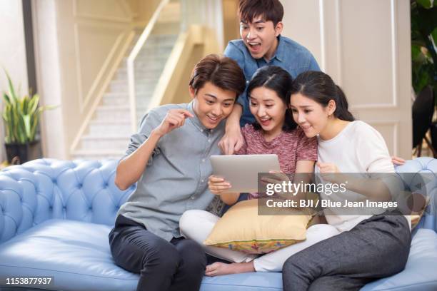 young friends using a digital tablet - surprised woman looking at tablet stock pictures, royalty-free photos & images
