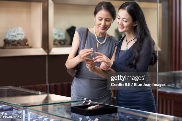 happy mother and daughter shopping in jewelry store - jewellery shopping stock pictures, royalty-free photos & images