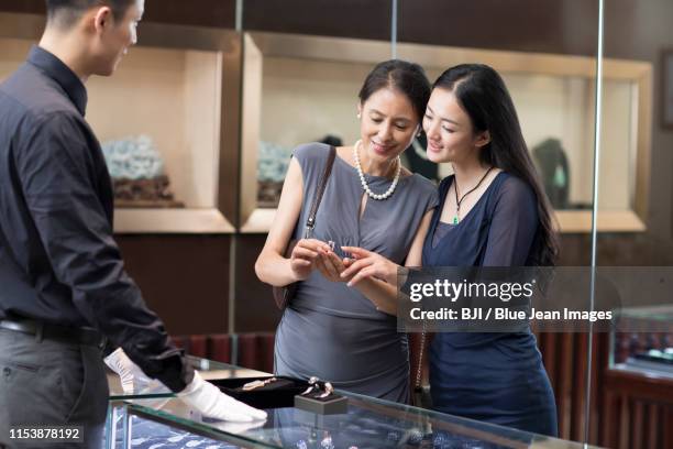 happy mother and daughter shopping in jewelry store - diamond jeweller stock pictures, royalty-free photos & images