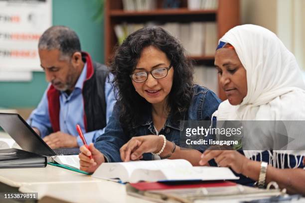 multi-ethnic adults education classroom - emigration and immigration stock pictures, royalty-free photos & images