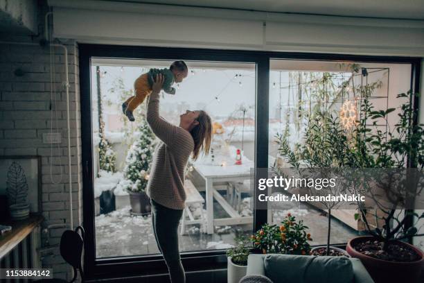 baby jongen en zijn moeder in hun appartement - winter baby stockfoto's en -beelden