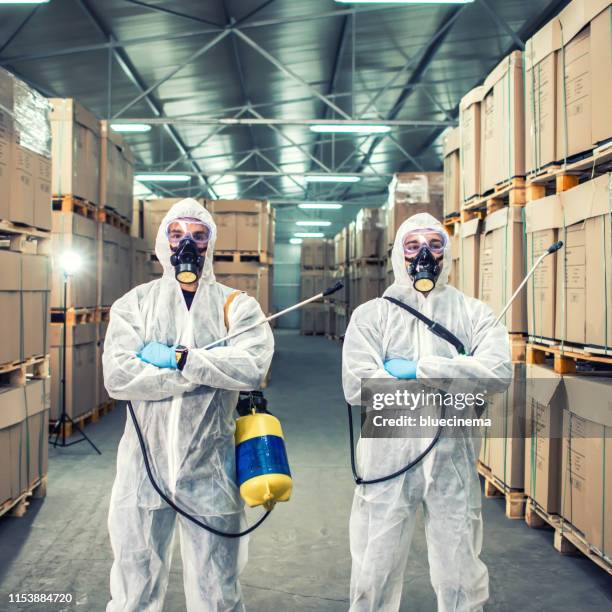 exterminators in warehouse spraying pesticides with sprayer - pest control equipment stock pictures, royalty-free photos & images