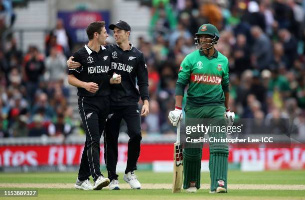 Matt Henry and Mitchell Santner of New Zealand celebrate the wicket of Mohammad Saifuddin of Bangladesh during the Group Stage match of the ICC...