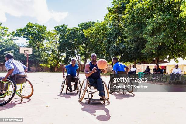 african wheelchair basketball players on the community ground playing a friendly match - wheelchair basketball team stock pictures, royalty-free photos & images