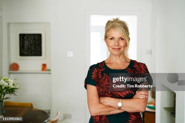 woman with her arms crossed, looking at camera - old lady at home stock pictures, royalty-free photos & images