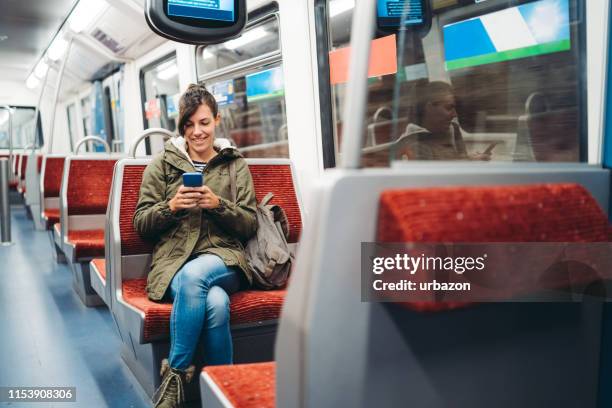 handy auf u-bahn-fahrt - bahnreisender stock-fotos und bilder