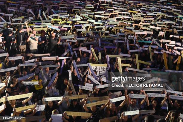 Demonstrators hold up banners during a rally organised by Hong Kong mothers in support of extradition law protesters, in Hong Kong on July 5, 2019. A...