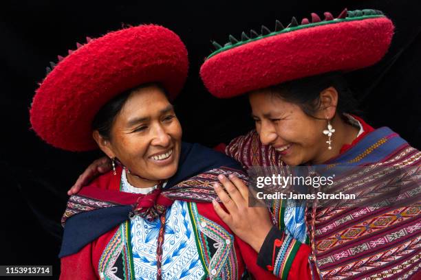 portrait of two local women who are close friends, in colourful, predominantly red, traditional local dress and hats, chinchero, sacred valley, peru (model releases) - perù foto e immagini stock