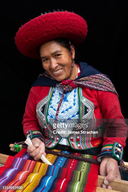 portrait of local woman weaver at her loom in colourful, predominantly red, traditional local dress and hat, chinchero, sacred valley, peru (model release) - femme perou photos et images de collection