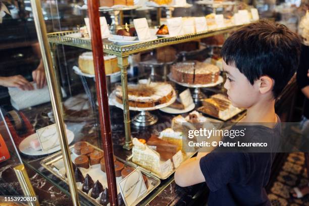 boy choosing a cake to eat - vienna austria bildbanksfoton och bilder