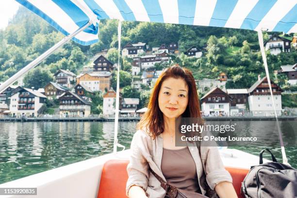 woman sitting in boat at hallstatt - gmunden austria stock pictures, royalty-free photos & images