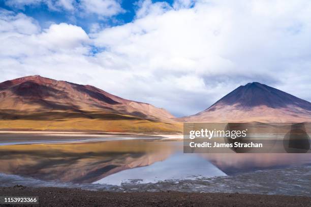 'painted mountain' and volcan licanabur (5920m) reflected in laguna verde, bolivian highlands, bolivia - licancabur lake foto e immagini stock