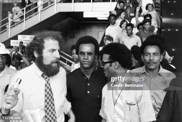 National Black Panther leaders, Huey Newton and David Hilliard are surrounded by supporters as Temple University law student, Steven Farber, leads...